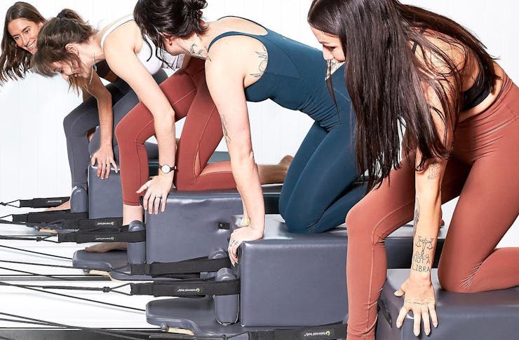 A group of women prepare for a pilates session.