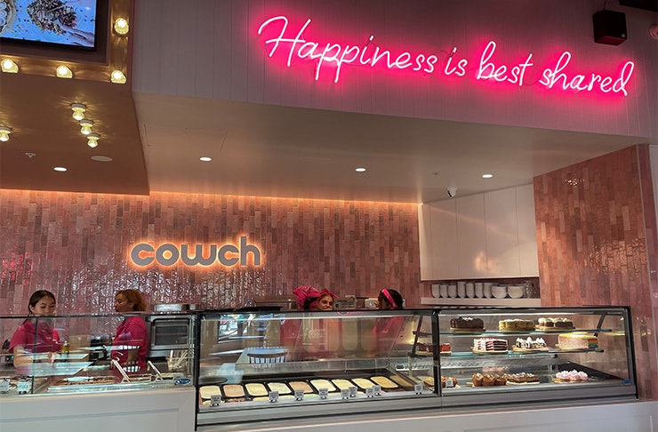 the counter of a dessert bar with a neon sign