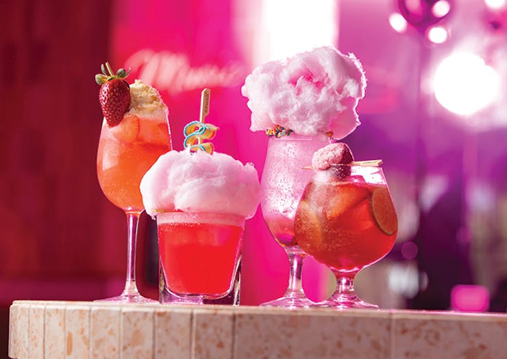 four pink cotton candy-topped cocktails 