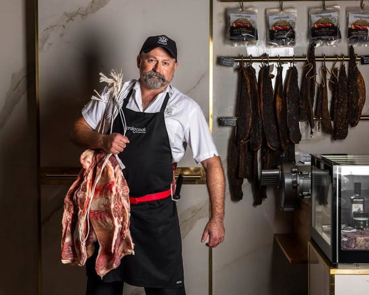 A man wearing an apron that reads 
