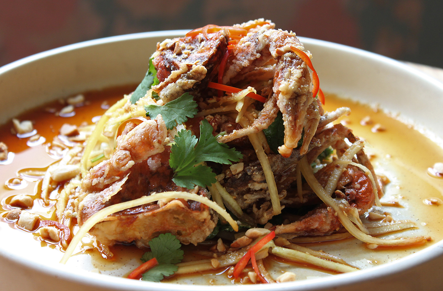 Soft Shell Crab with shredded Kohlrabi sits on a plate looking delicious.
