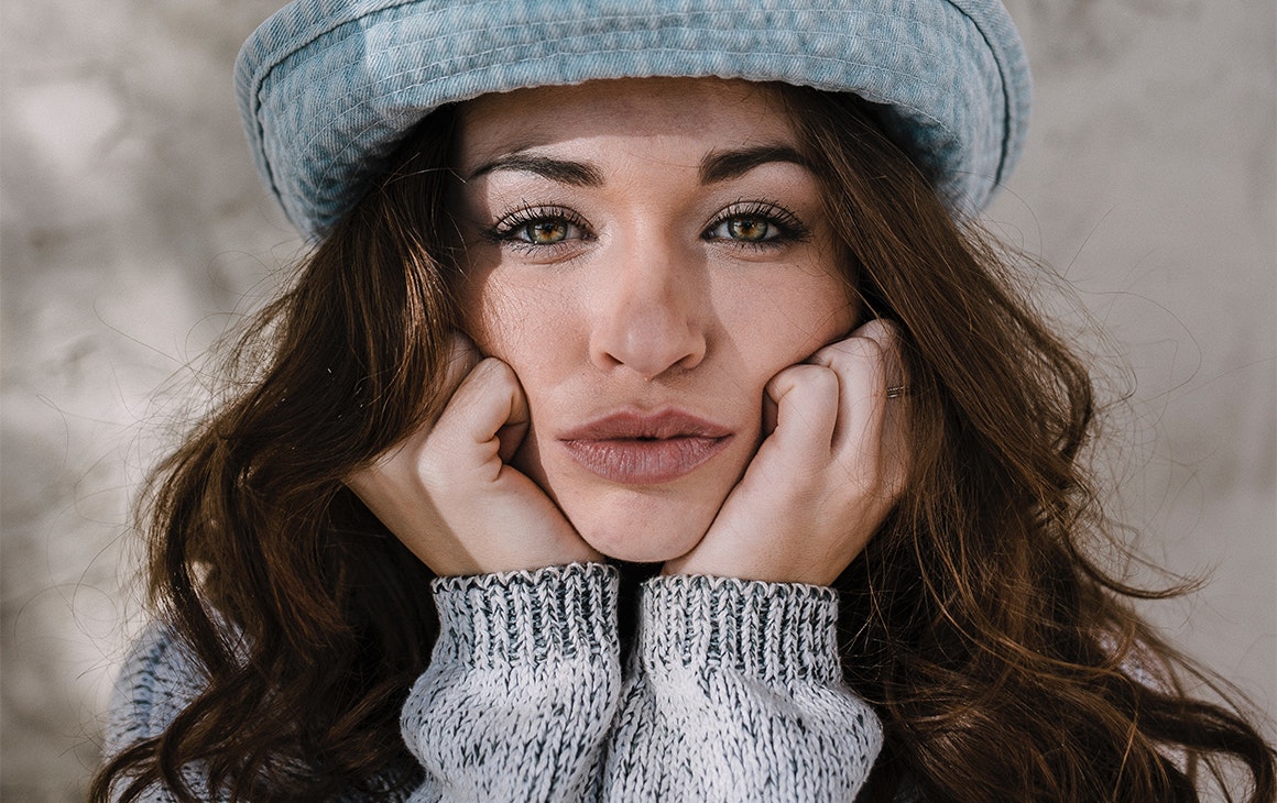 Brown haired woman with face resting on her hands