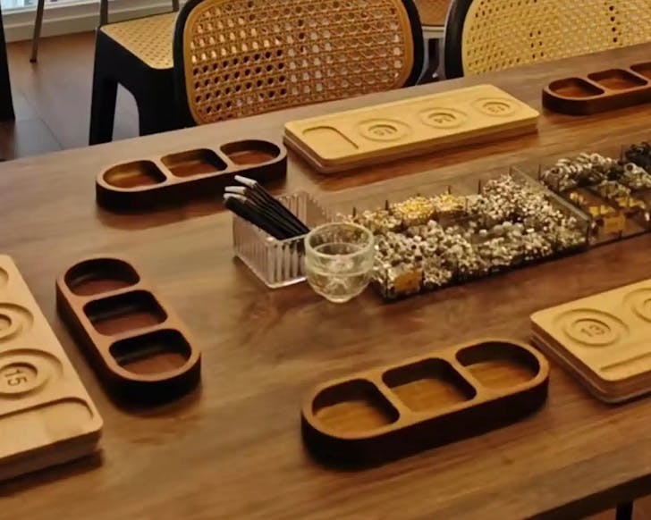 A wooden table with wooden dishes and utensils laid out for a crystal making workshop.