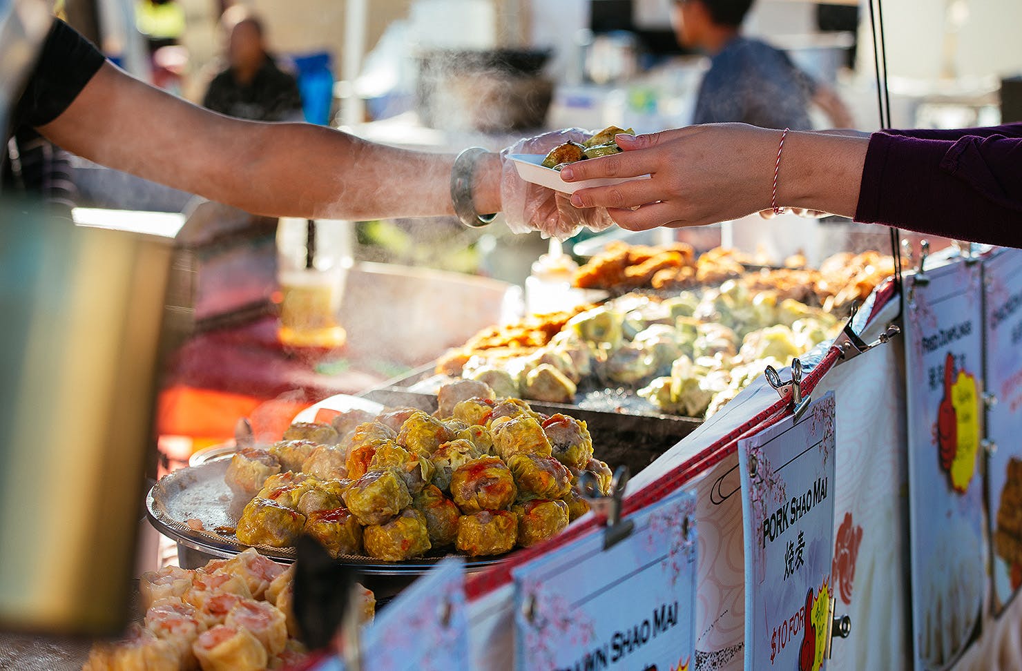 Hands exchange delicious looking snacks at the cultural fest.