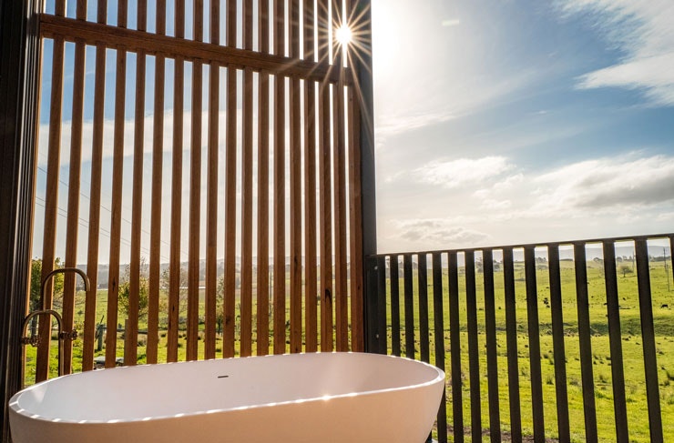 An outdoor bath tub with a view across green paddocks