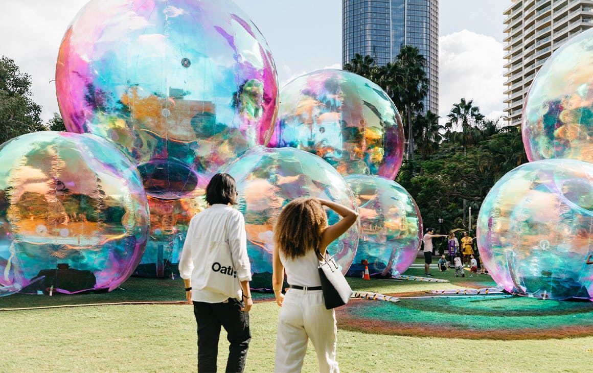 two people in front of giant bubble like structures