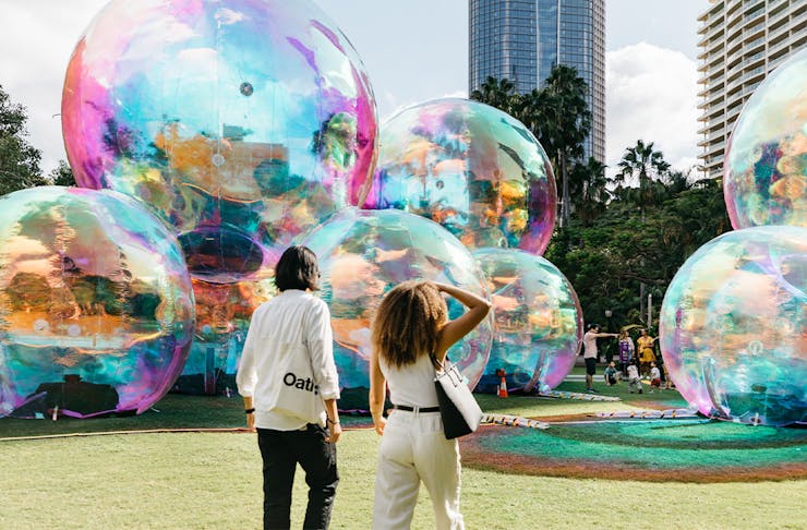 two people in front of giant bubble like structures