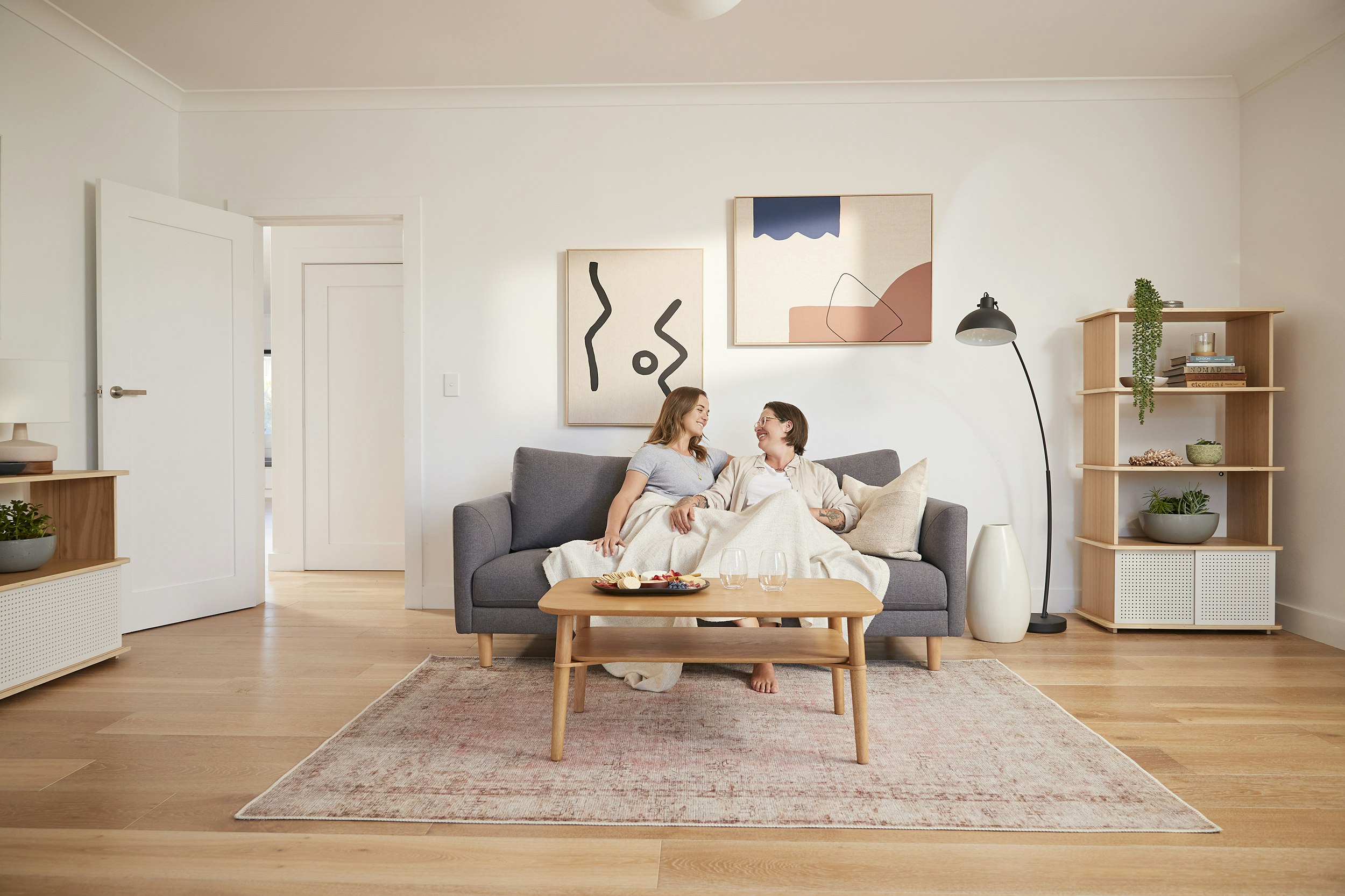 two women sitting on a couch in a nicely decorated room