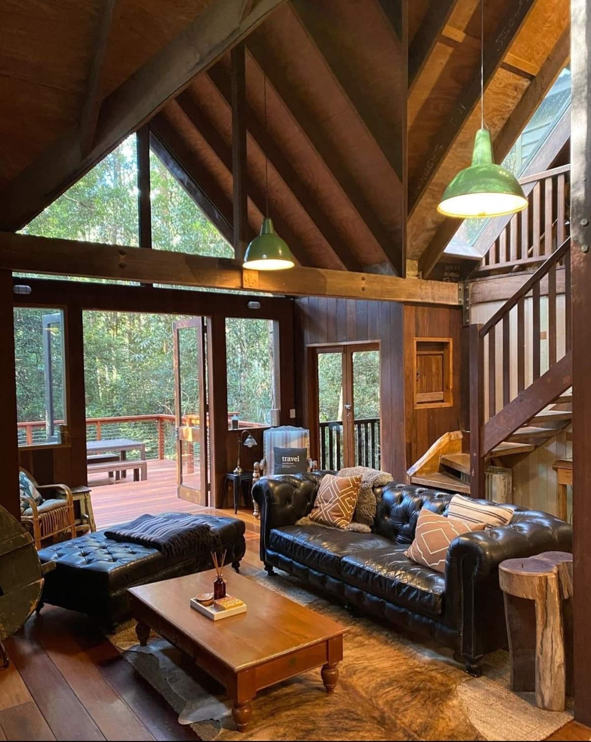 lounge room of a treehouse cabin looking out to a rainforest