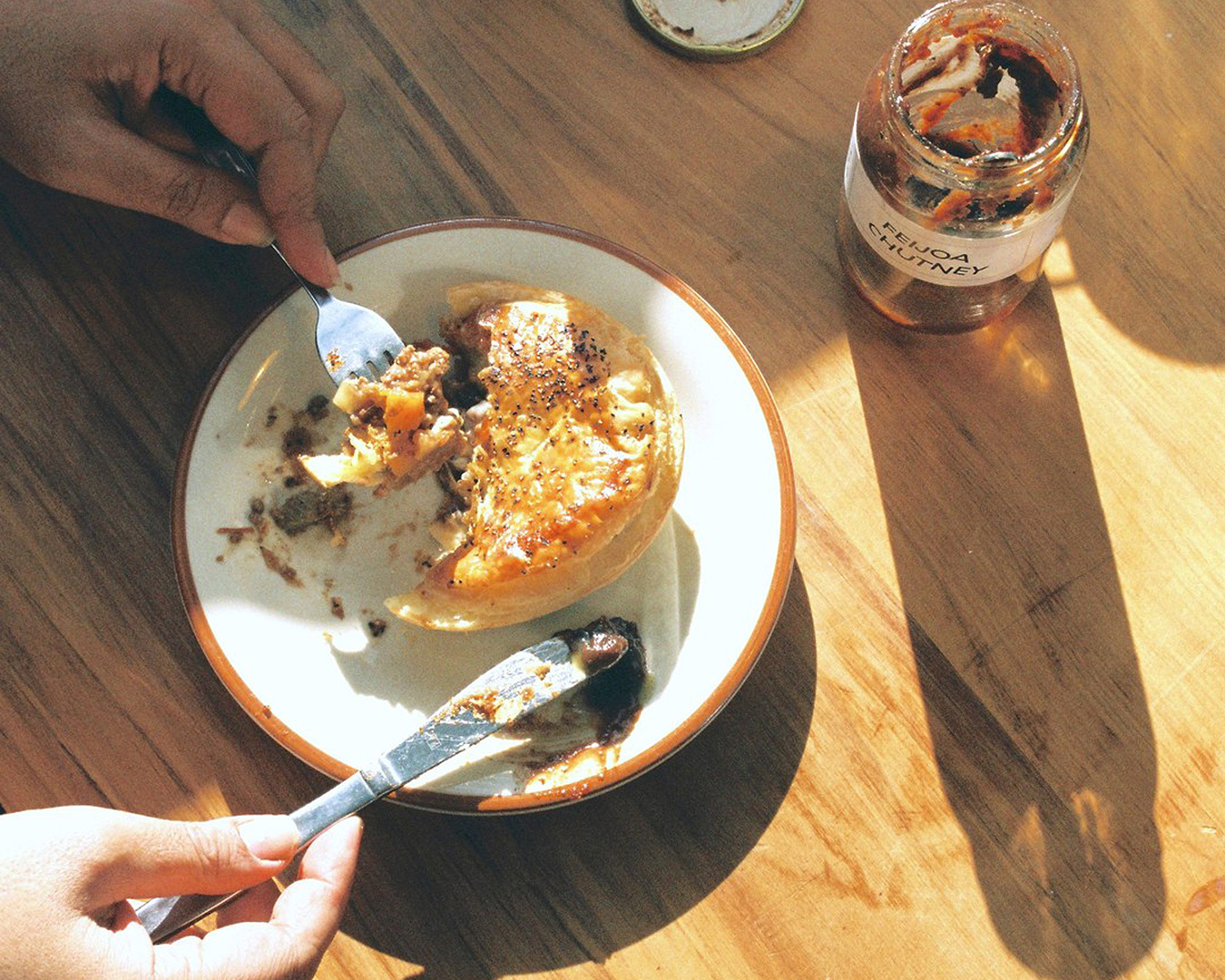 A person tucks into a mouthwatering bolognese and provolone pie with a knife and fork. 