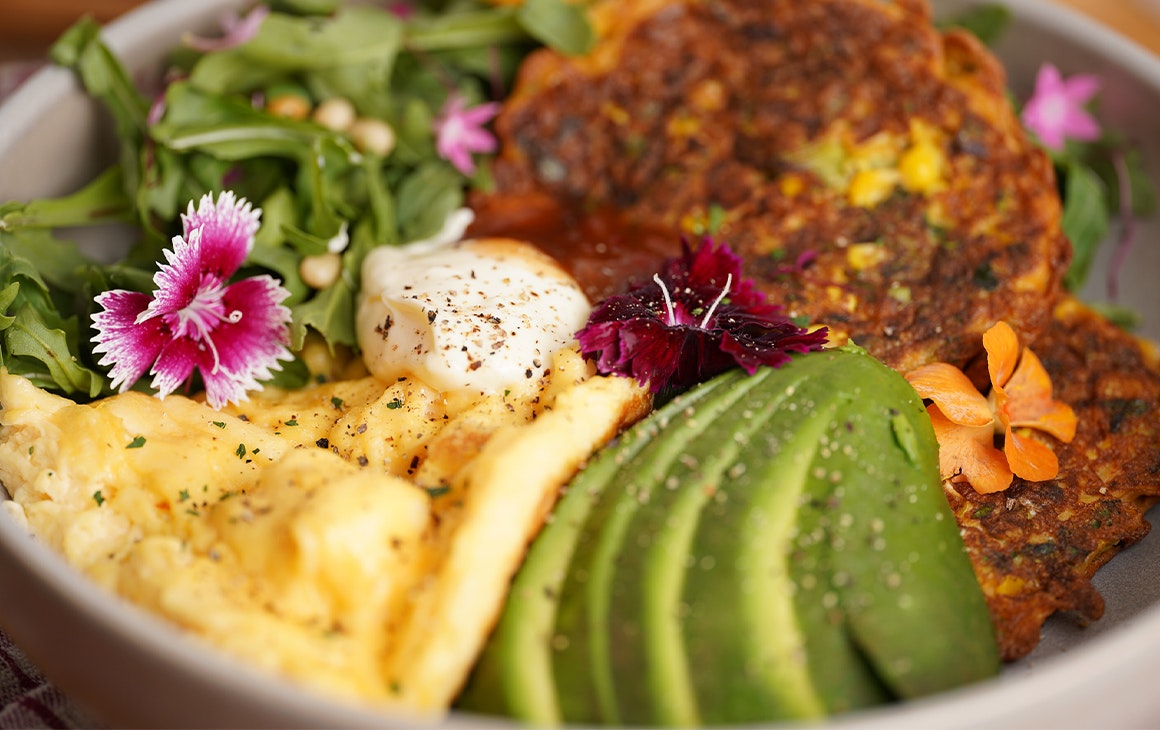 a bowl of corn fritters and avocado