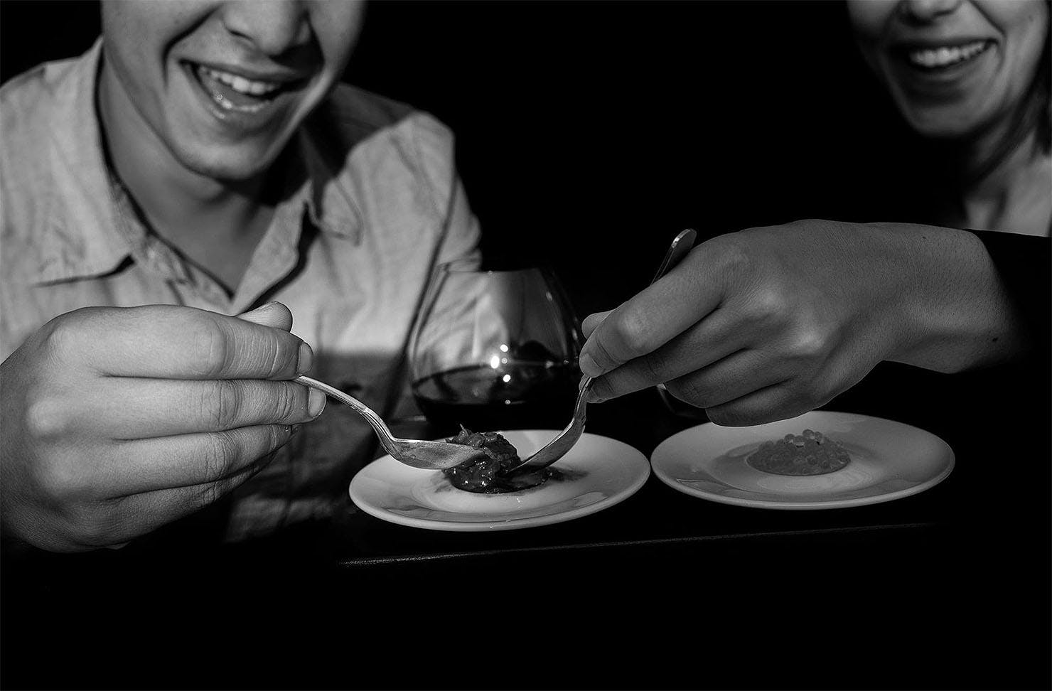 Two people enjoy a dish in the dark.