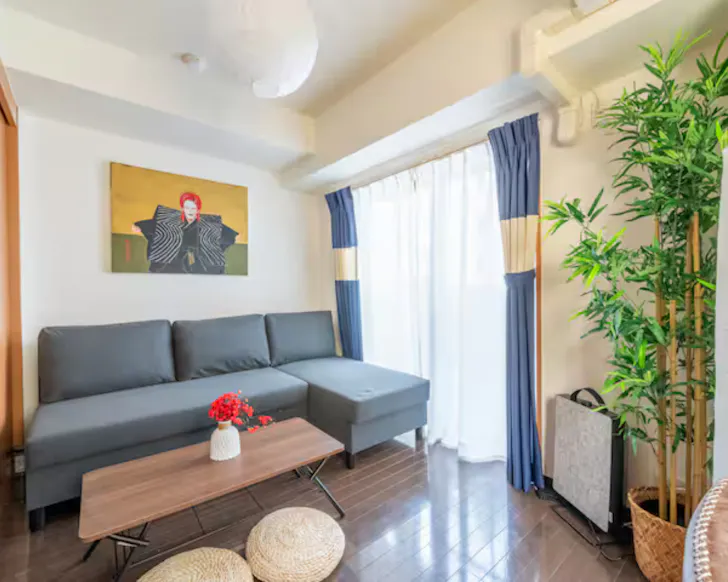 The living area in the clean, minimalist Bowie Stay Airbnb with a painting of David Bowie over the sofa.
