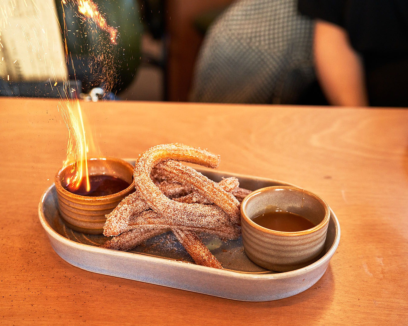 Flaming churros, just one of many delicious dishes you'll find at De Nada, one of Auckland's best new restaurants for 2022. 