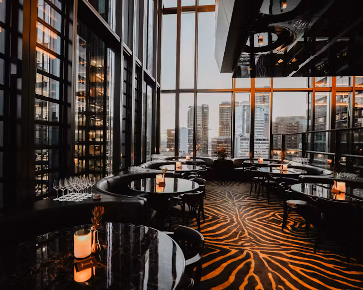 A dimly lit but impressive bar in Sydney CBD, with floor to ceiling glass windows.