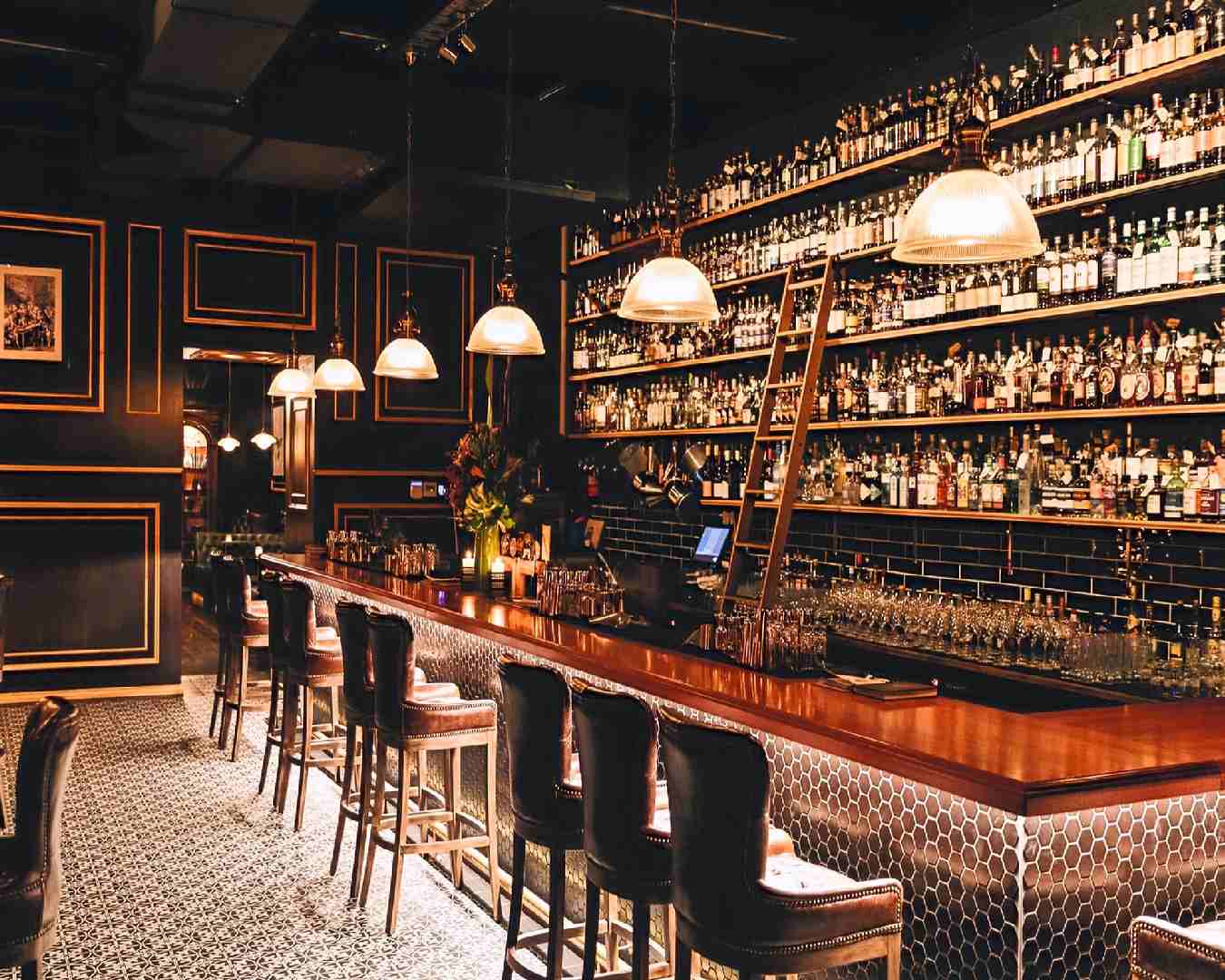 a dimly lit bar area at brisbane cocktail bar Death & Taxes