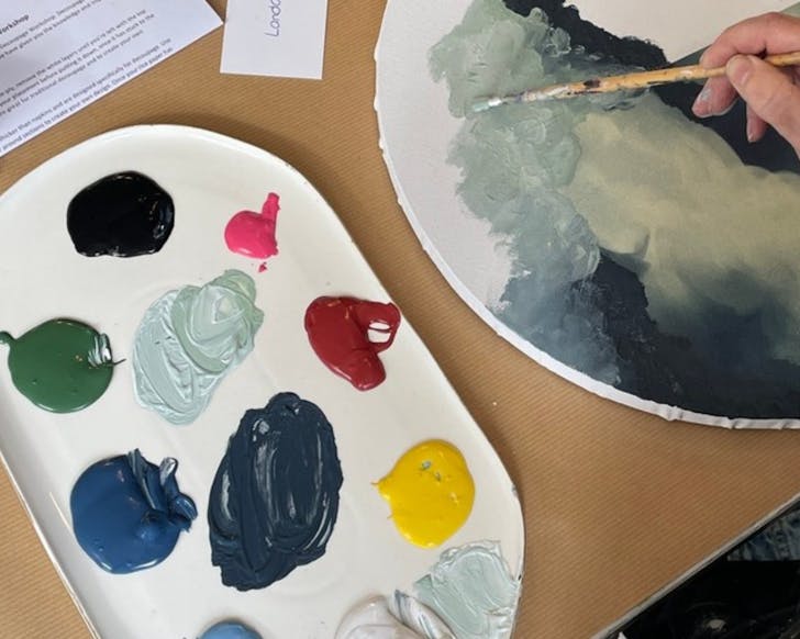 A lady in a decoupage workshop blending the decoupage paper with chalk paint.