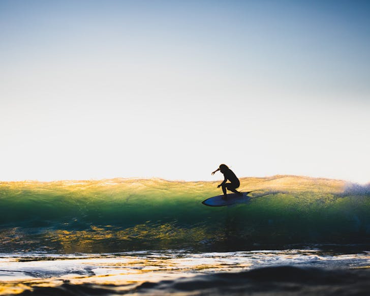 the deep north festival surfer on a wave shadow against a sunrise 