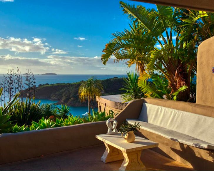 A terrace drenched in sunlight at Delamore Lodge on Waiheke Island, one of the best luxury hotels in NZ.