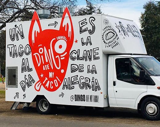 A food truck with a painting of a dingo on its side. The text reads 