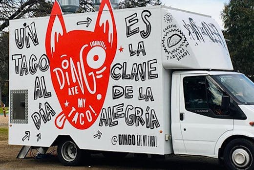 A food truck with a painting of a dingo on its side. The text reads