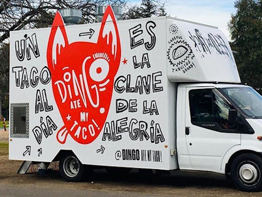 A food truck with a painting of a dingo on its side. The text reads 