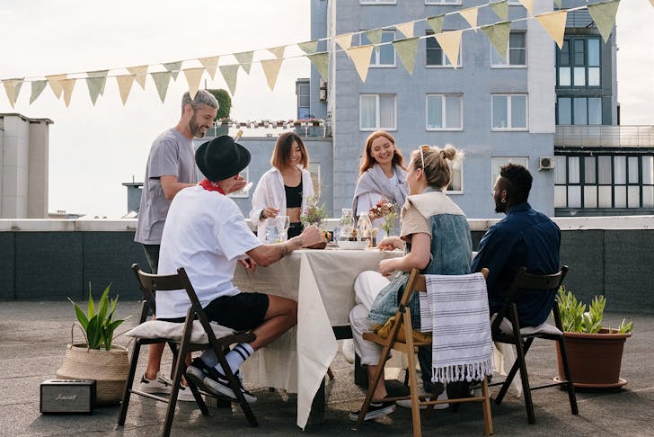 A group of people at a rooftop dinnerparty.