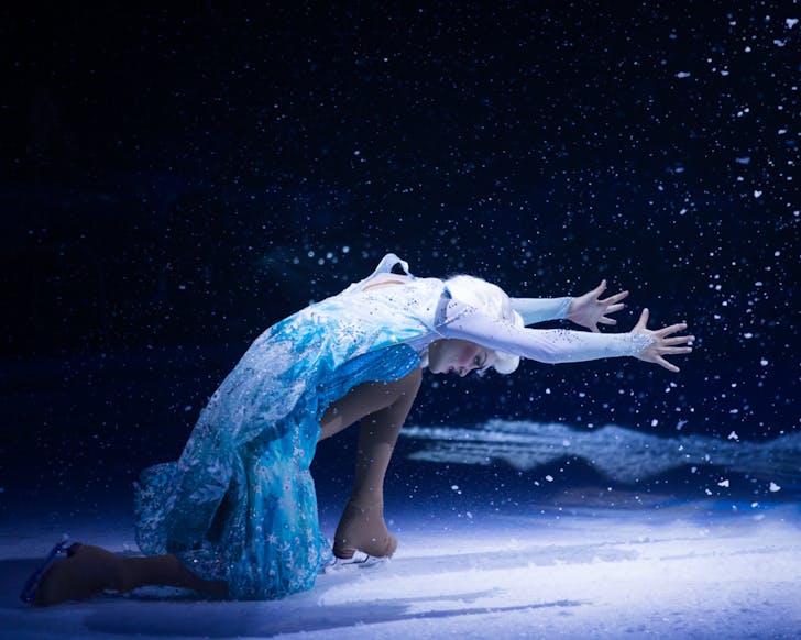 An ice-skating Elsa strikes a pose on a snowy stage.