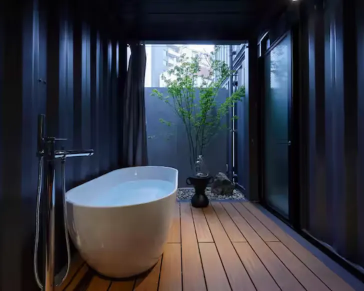 A hot tub bath in a dark, moody shipping container Airbnb in Osaka