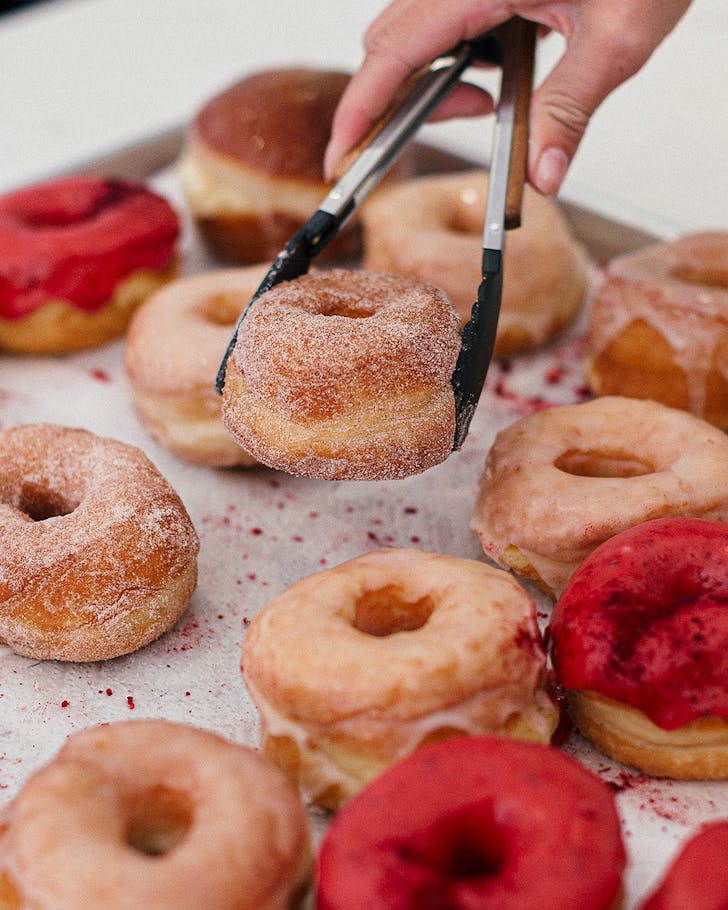 Someone picks up a deliciously sugary doughnut from doe donuts.