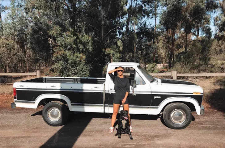 A person in front of a truck with their dog