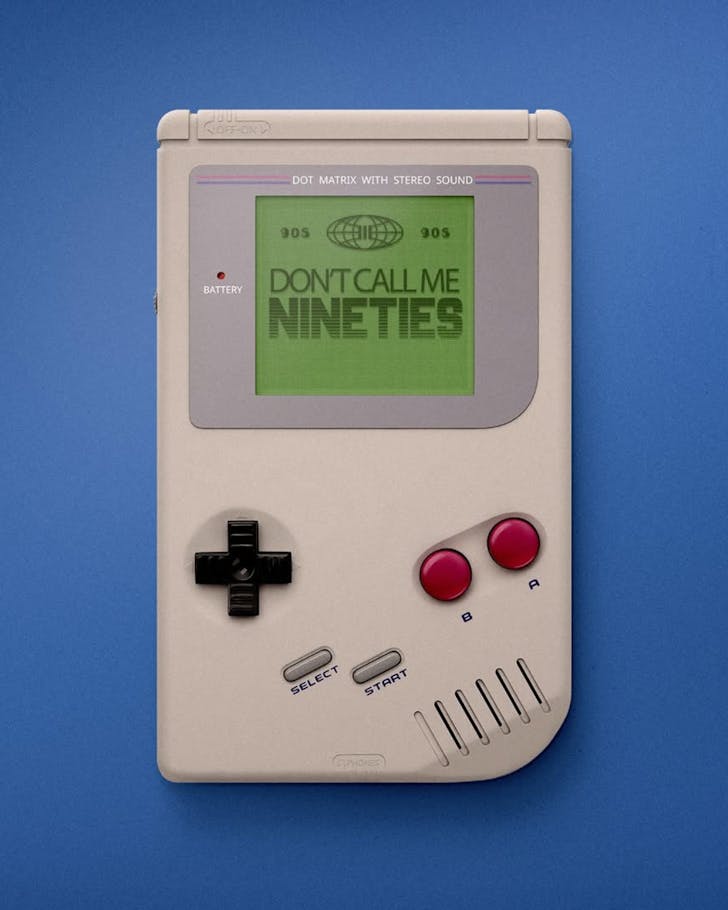 An old  Gameboy lying on a blue background with the words 'DON'T CALL ME NINETIES' on the green screen.
