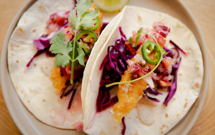 a plate of two fish tacos