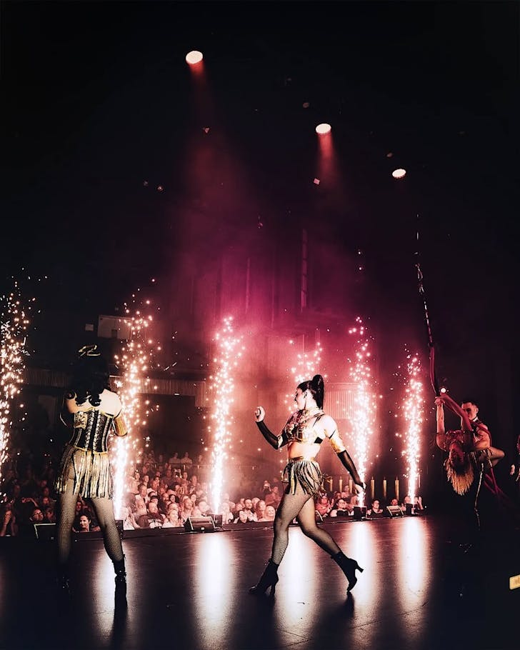 Constumed Draculas performers put on a live show in front of bursting shoots of sparks and a large crowd.