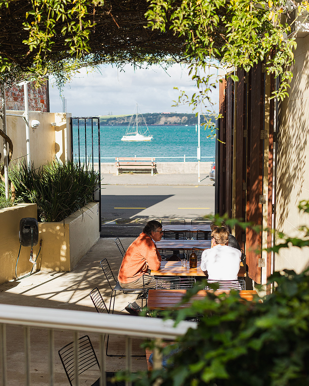People sit in the sun-drenched courtyard at Dulcie in Devonport, one of the best breakfasts in Auckland.