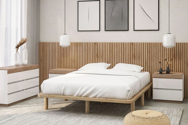 A Scandi-style bedroom, complete with a plush white bed and wooden bed base. 