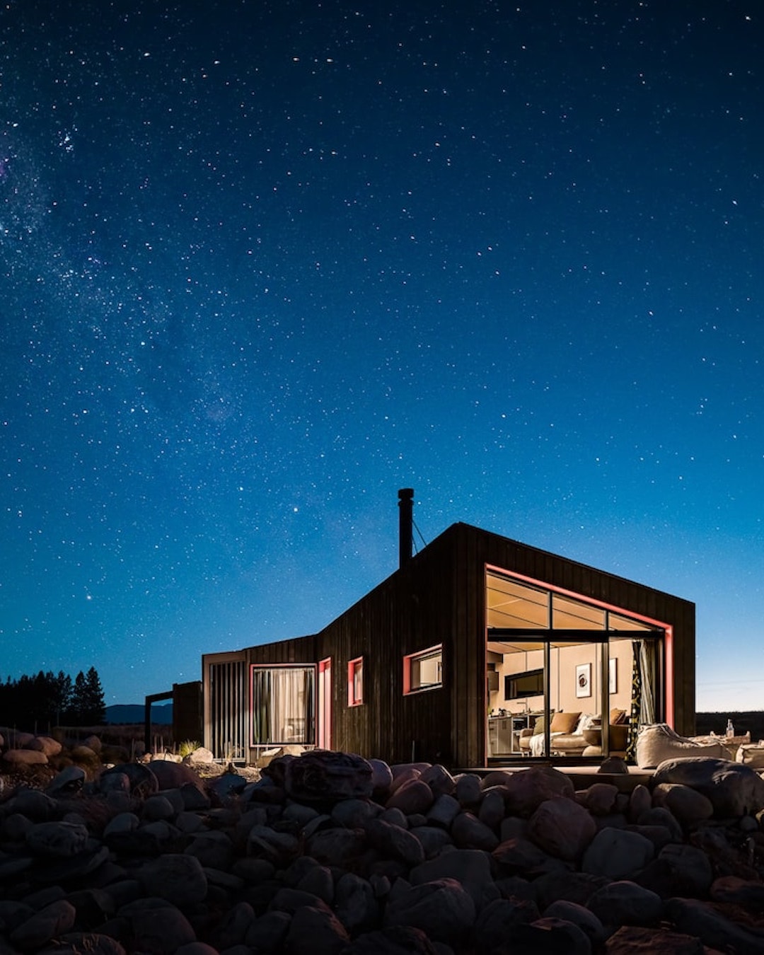 A contemporary New Zealand Airbnb under the Milky Way by night