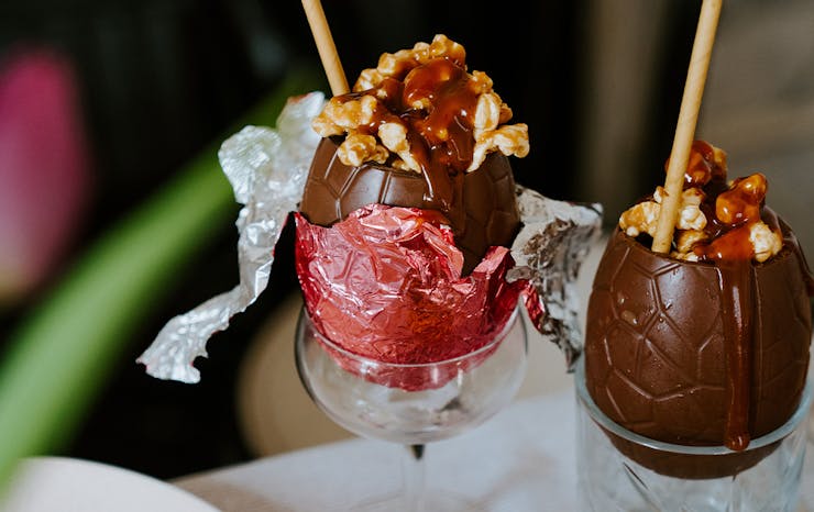 two chocolate easter eggs filled with cocktails and popcorn