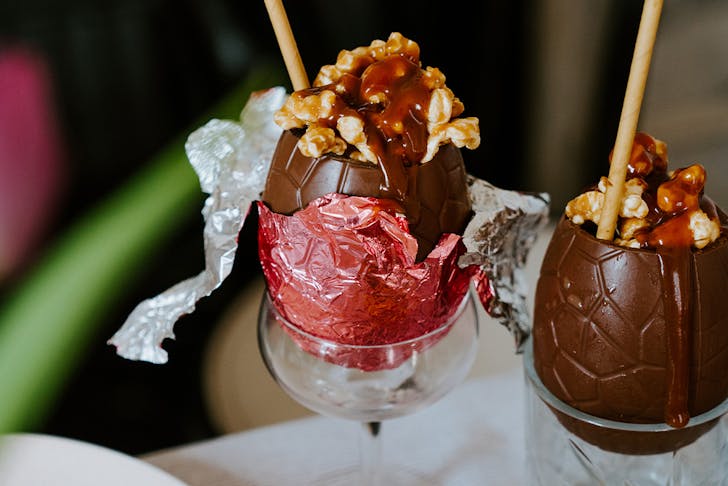 two chocolate easter eggs filled with cocktails and popcorn