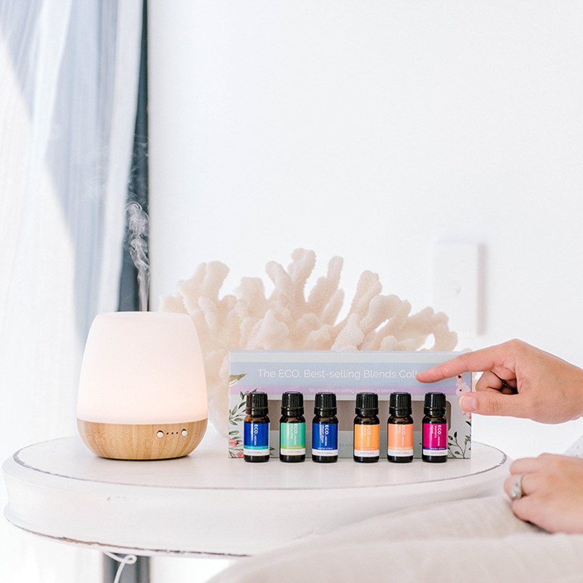 a white diffuser next to a row of essential oils