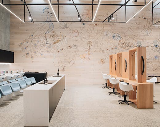 An image of a sleek hair salon, with a mural along one wall