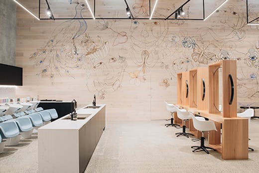 An image of a sleek hair salon, with a mural along one wall