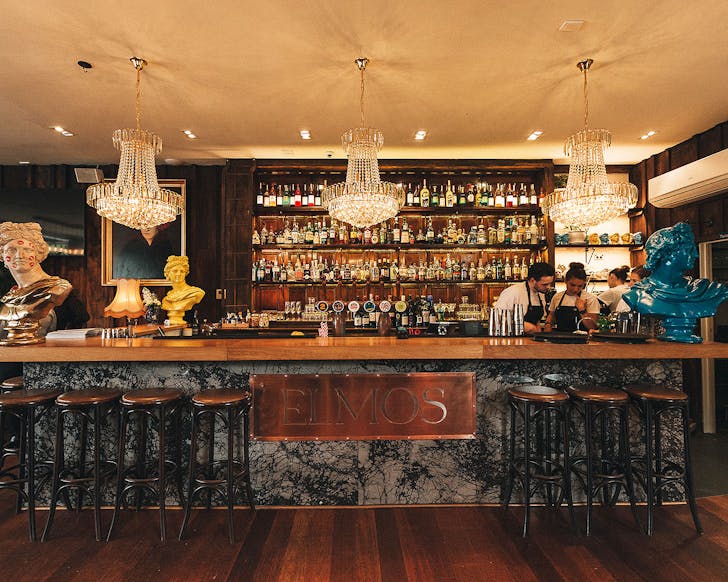 A sprawling bar with marble-like front and wooden timber top with a large sign that reads, 'ELMOS', a stellar option for Ponsonby restaurants