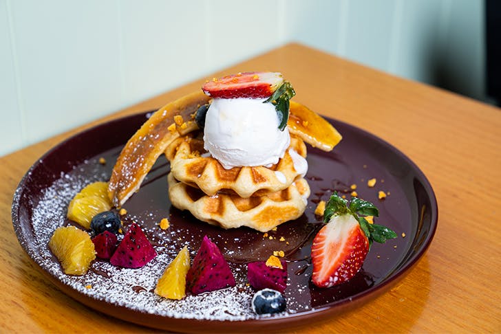 a plate of waffles topped with fruit