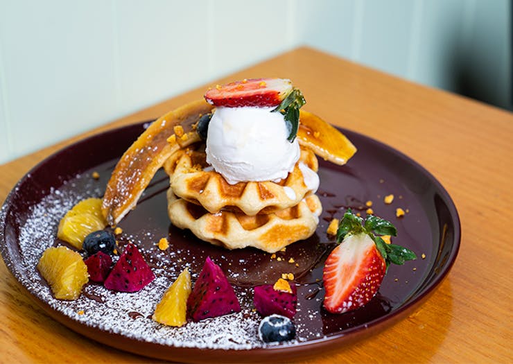a plate of waffles topped with fruit