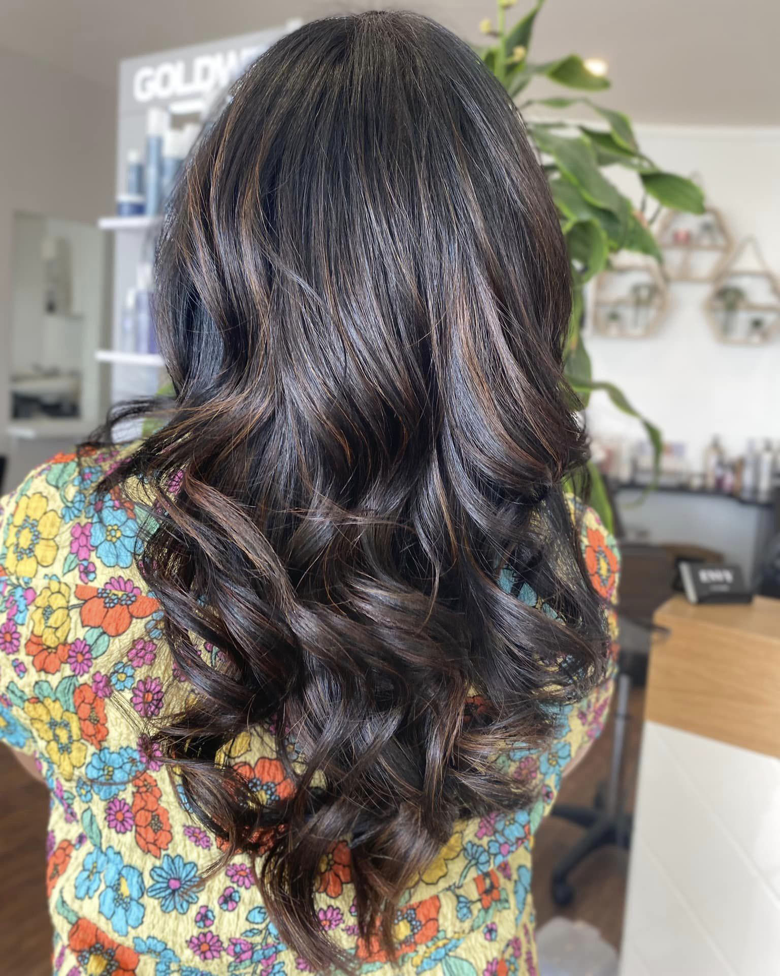 Freshly cut dark brown hair with light brown highlights done at Envy Hair Salon, one of the best hairdressers in Tauranga.