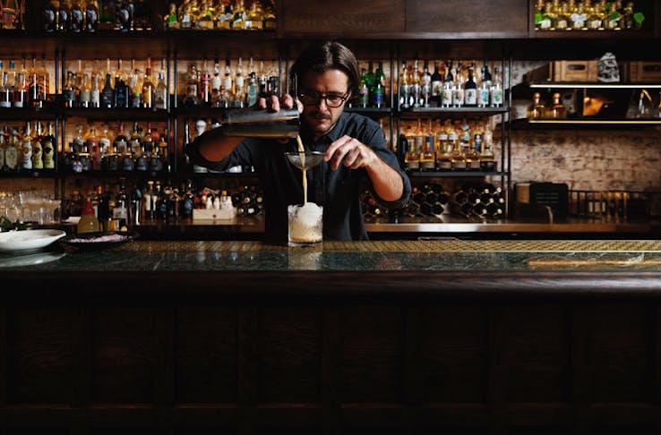 A barman pouring a cocktail at Esteban. 