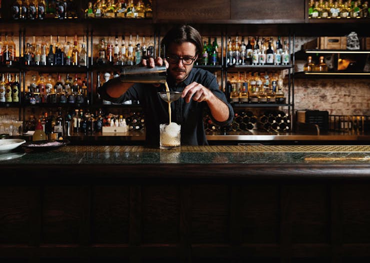 A barman pouring a cocktail at Esteban. 