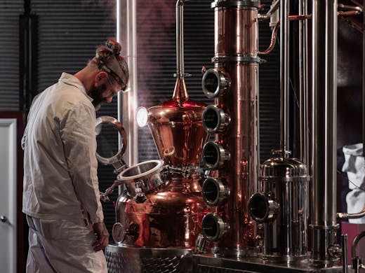 A person working the gin still at Ester Spirits Distillery & Tasting Room