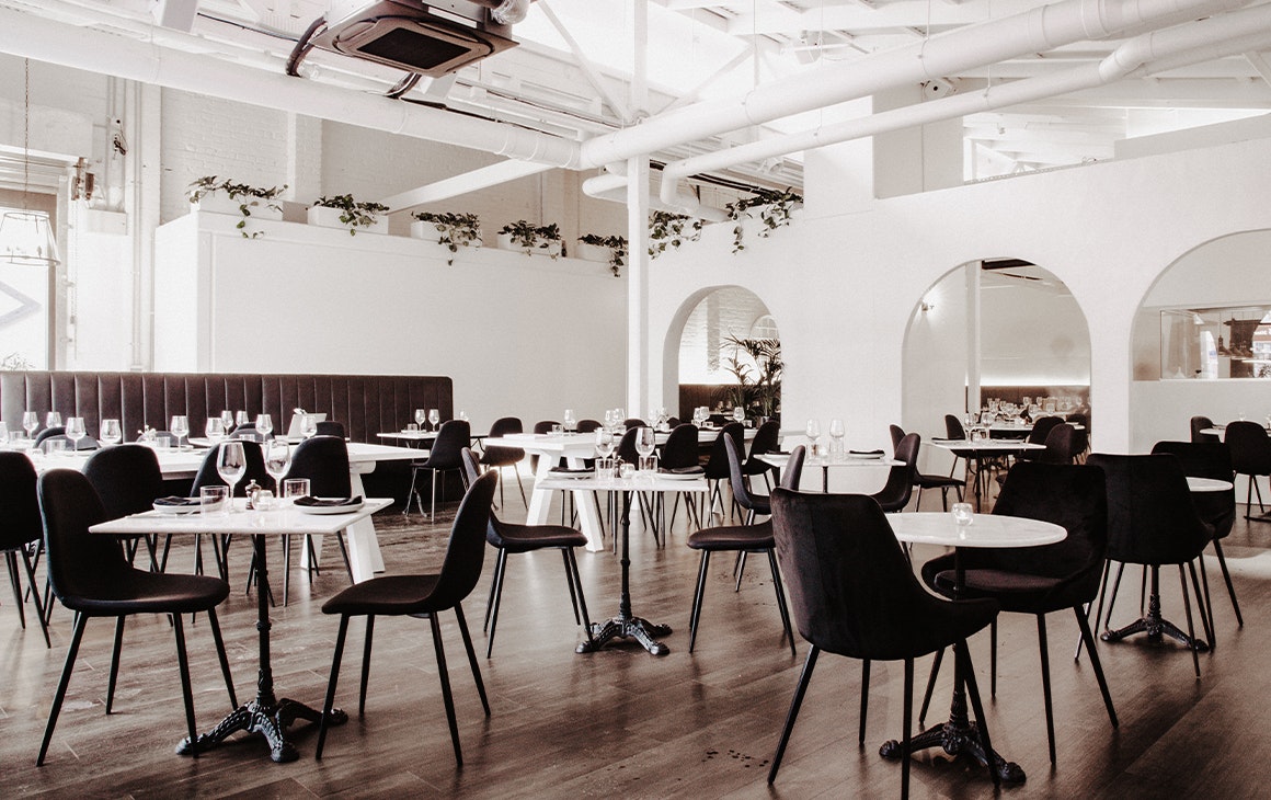 interior of evita, with white walls and black seating